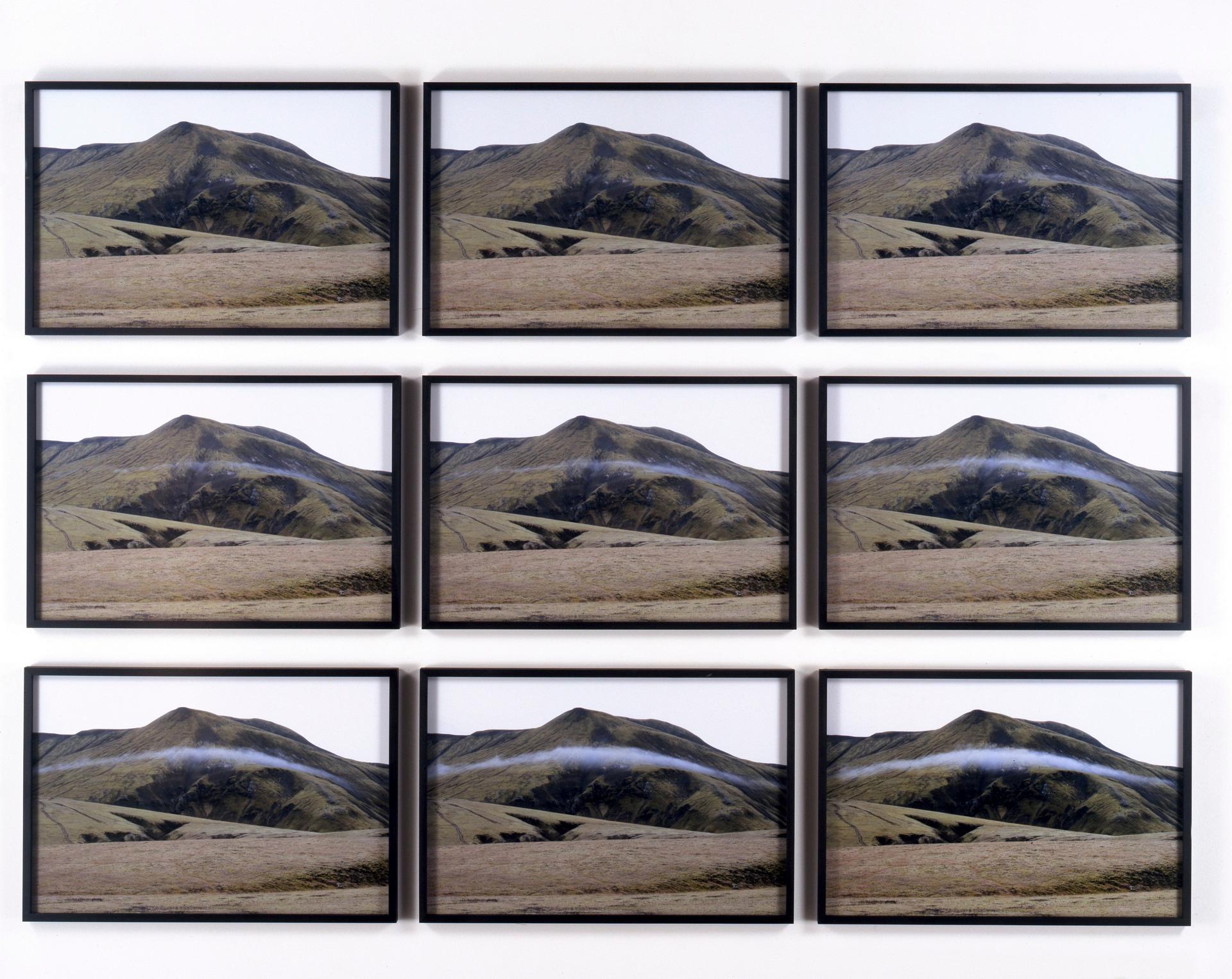 A grid of nine framed photographs, arranged in a grid of three rows by three columns, showing sequential photographs of a green mountain as a cloud forms and passes across its slopes.