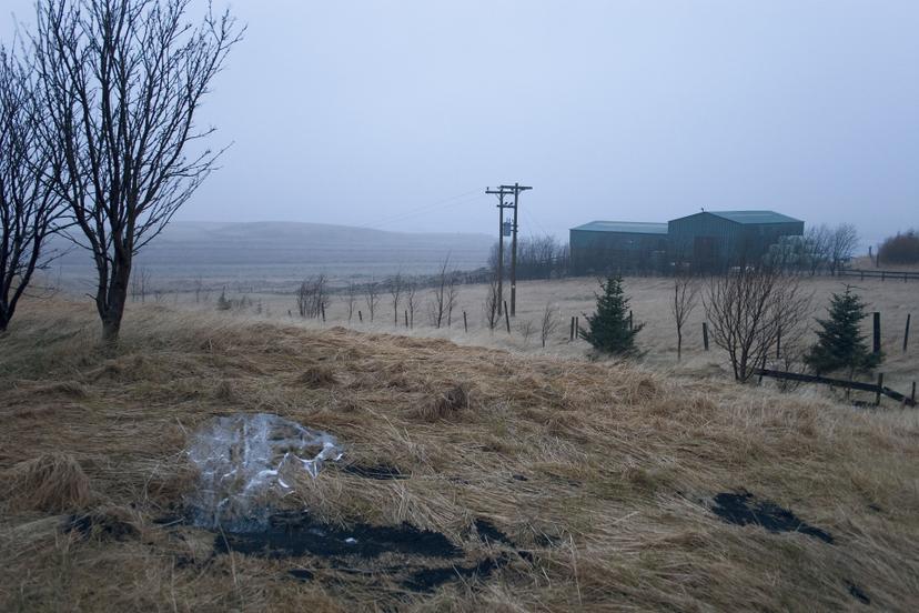 Final stage of Melting ice on Gunnar’s land (2008), Olafur Eliasson. Only a trace of ice is visible among dark, damp soil, marking the work’s gradual disappearance.